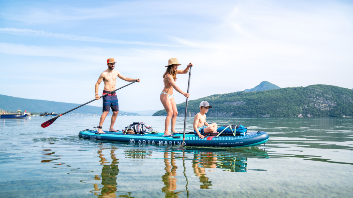 parents with a child paddling on an inflatable sup board 